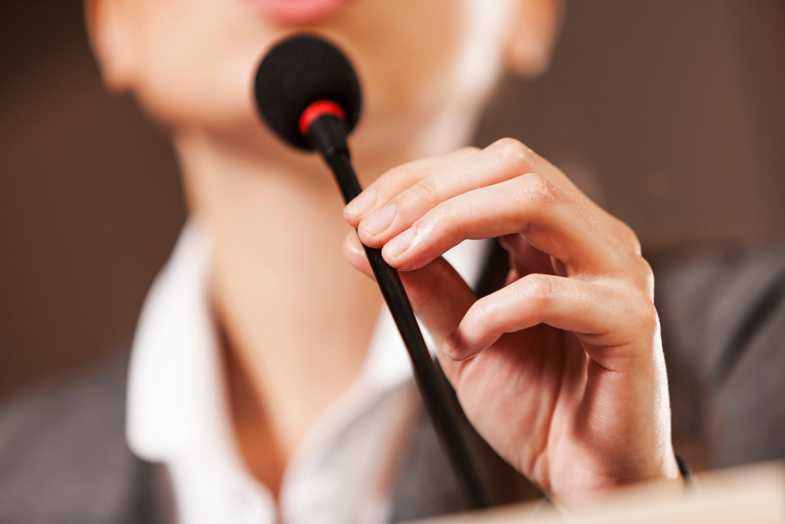 a woman adjusting the microphone on a podium