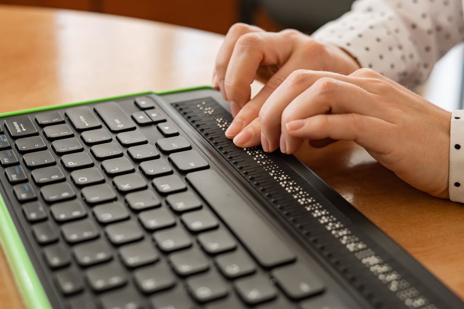 a woman using a keyboard with braille keys