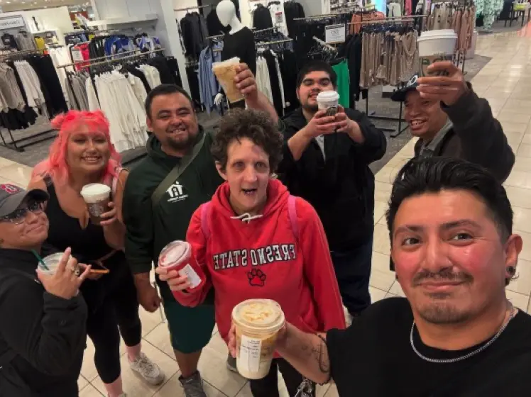 A group of people holding up cups of coffee.