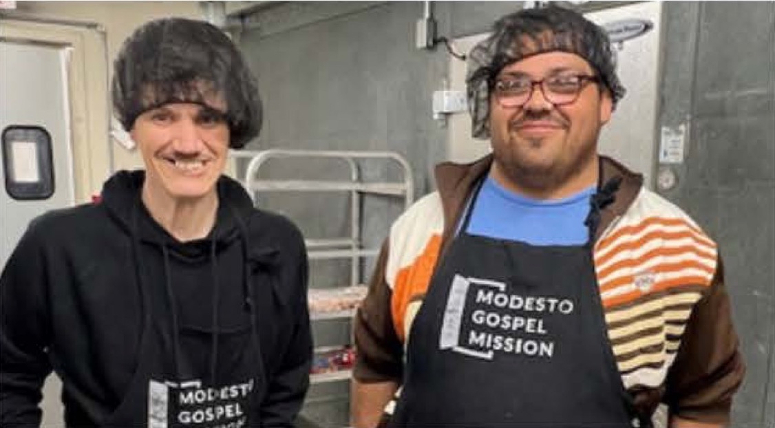 Armando G. and Daniel M. wearing Modesto Gospel Mission aprons while volunteering together at the Modesto Gospel Mission.