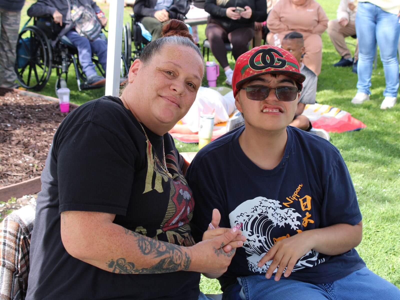 CV Training Center consumer and staff member smiling together during an outdoor community life skills program in Stockton, CA