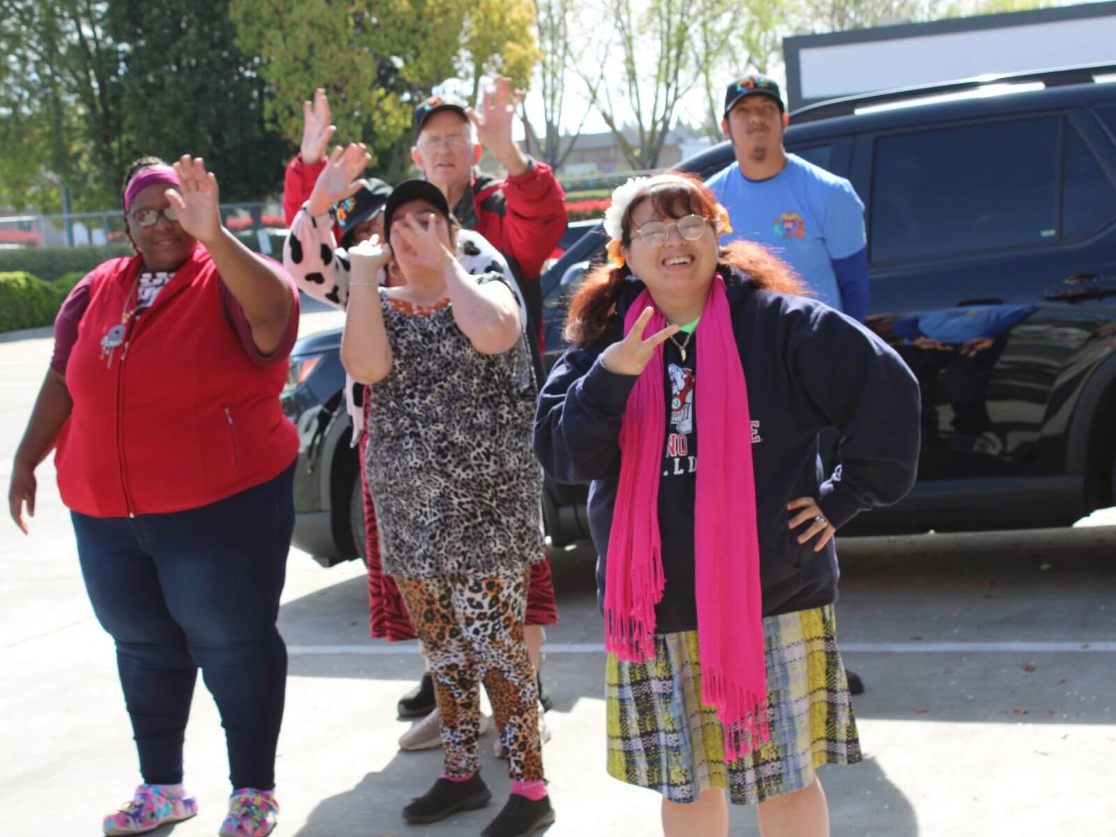 CV Training Center consumers smiling, waving, and posing during an outdoor life skills and community engagement activity in Stockton, CA