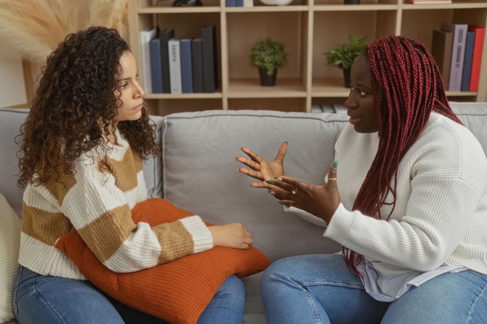 two women talking on a couch