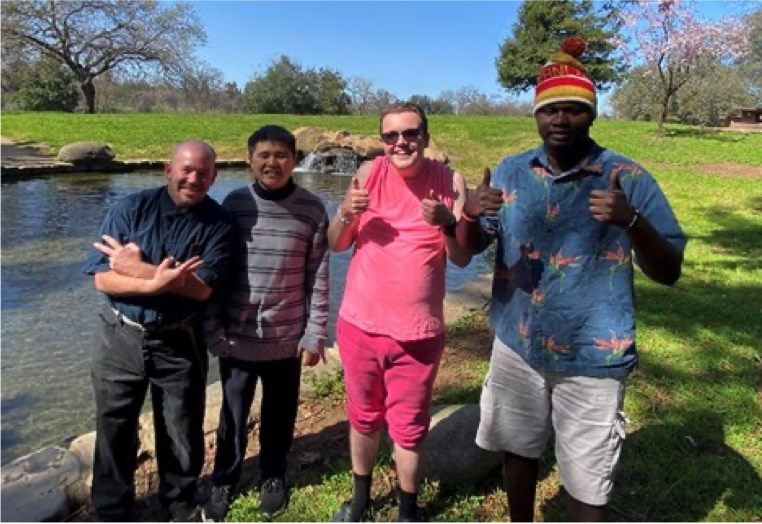  Matthew S., David V., Henry B., Kenneth T. standing by a lake, giving a thumbs up. 
