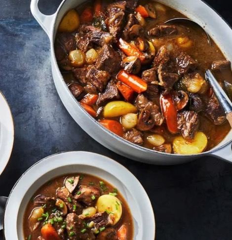 A pot and a bowl of Dutch oven classic beef stew.
