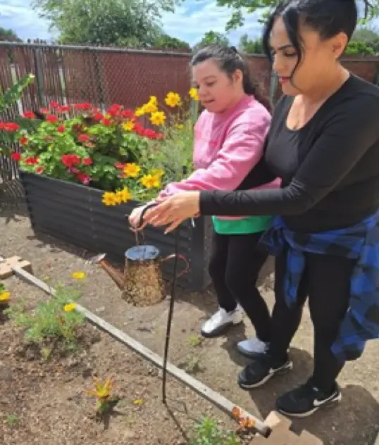 Erica and Nancy watering the garden.